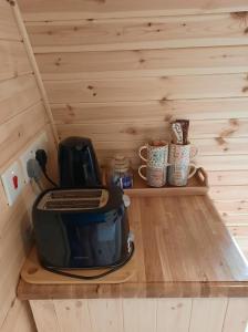 a toaster sitting on a wooden shelf in a room at Bwlcheinion Sea View Glamping in Machynlleth