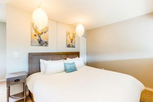 a bedroom with a white bed and two pictures on the wall at Watch Hill Lofted in Silverthorne