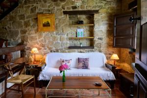 uma sala de estar com um sofá branco e uma mesa em La Xamoca Apartamentos Rurales em Campiellos