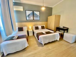 Habitación de hotel con 2 camas y mesa en CH Las Murallas, en Madrid