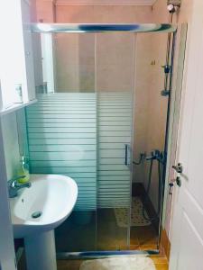 La salle de bains est pourvue d'une douche et d'un lavabo. dans l'établissement Central Square Apartment 1, à Pyrgos
