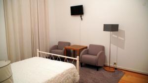 a bedroom with two chairs and a bed and a tv at Casa Abrigo do Lagar in Amares
