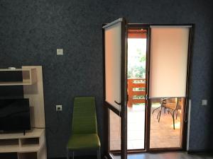 a room with a door and a green chair at Guest yard «Moonlight» in Gagra