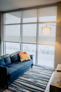 a blue couch in a living room with a large window at Kasa The Gulch Nashville in Nashville