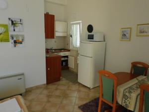 a kitchen with a table and a white refrigerator at Villa Filip in Brela