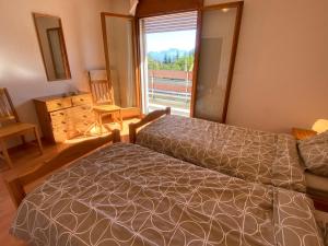 ein Schlafzimmer mit einem Bett und einem großen Fenster in der Unterkunft Alpine apartment in Swiss village of Torgon in Torgon