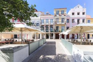 an empty street with tables and umbrellas at Belem Prestige by Homing in Lisbon
