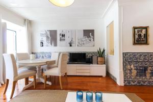 uma sala de estar com uma mesa e cadeiras e uma televisão em Belem Prestige by Homing em Lisboa
