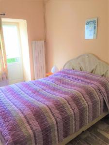 a bed with a purple comforter in a bedroom at Camping & Resort Valle Romantica in Cannobio