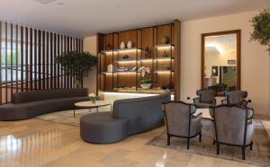 ein Wohnzimmer mit Sofa, Stühlen und einem Spiegel in der Unterkunft Hotel Afonso V & SPA in Aveiro