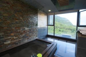 uma grande piscina num quarto com janelas em Jiaoxi Guanjinglou Hot Spring Club em Jiaoxi