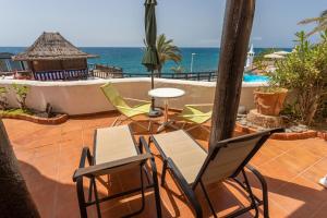 un patio con sillas, una mesa y una piscina en Altamar 28 with terrace&pool By CanariasGetaway, en Playa del Águila