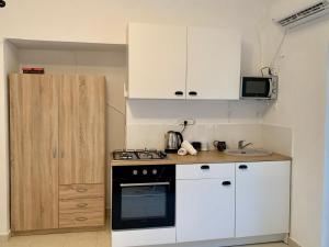 a kitchen with white cabinets and a stove top oven at Shantell Boutique Apartments in Netanya