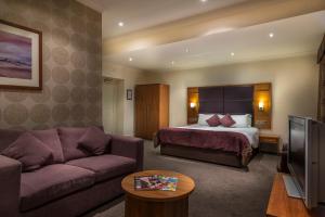 a hotel room with a bed and a couch at The White Hart Hotel, Boston, Lincolnshire - The Coaching Inn Group in Boston +54 photos