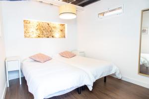 Una cama blanca en una habitación con un cuadro en la pared en Diana de Columela by Cadiz Time, en Cádiz
