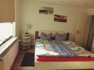 ein Schlafzimmer mit einem Bett mit zwei Kissen und einem Fenster in der Unterkunft Nordsee in Wilhelmshaven