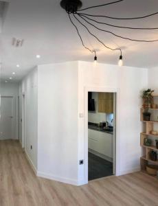 sala de estar con paredes blancas y cocina en Apartamento Vive Zaragoza II, en Zaragoza