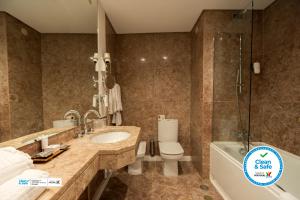 a bathroom with a sink, toilet and bathtub at Hotel Florida in Lisbon