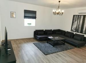 a living room with a black couch and a table at Laurentroom Central Park in Ukmergė