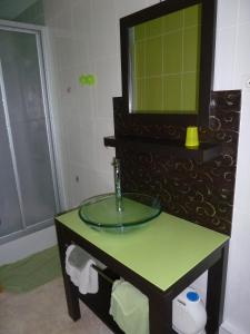 y baño con lavabo de cristal y espejo. en Les Pres-Salés, en Courtils