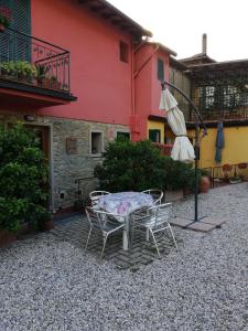 een patio met een tafel en stoelen en een parasol bij CASA ANTONIETTA in Bivigliano