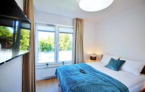 a bedroom with a bed and a large window at Apartamenty NAVIGATOR PORT-NADMORSKIE TARASY in Kołobrzeg