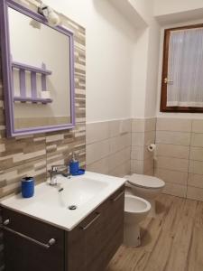 łazienka z umywalką, toaletą i lustrem w obiekcie CASA ANTONIETTA w mieście Bivigliano +9 zdjęć