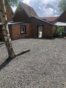 a brick house with a tree in front of it at LA MARLIERE maison de charme à la campagne in Houthem