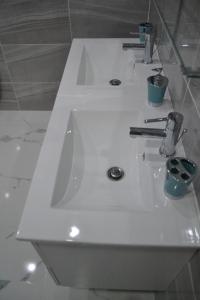 łazienka z 2 umywalkami w białej łazience w obiekcie Genius Apartments w Alicante
