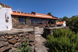 a stone house with a stone wall at Casa Elba in Isora