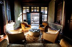 Guest House Old Plovdiv في بلوفديف: غرفة معيشة مع كراسي وطاولة ونوافذ