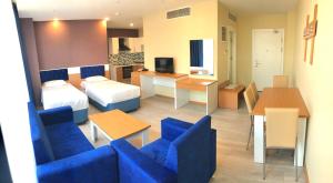 pokój hotelowy z 2 łóżkami i niebieskimi krzesłami w obiekcie SKYBLUE İSTANBUL HOTEL w Stambule