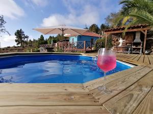 a glass of wine sitting on a table next to a swimming pool at La Somadita Tinizara in Tijarafe