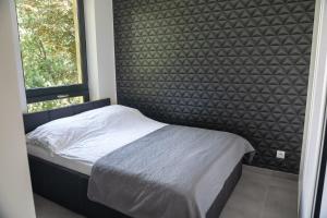 mała sypialnia z łóżkiem i oknem w obiekcie Apartamenty Dworcowa 45 w mieście Gliwice