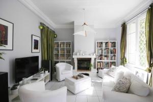 un soggiorno con mobili bianchi e TV di Les petits poissons ad Avignone