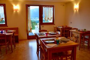 a dining room with tables and chairs and windows at Agritur Fiore in Fondo