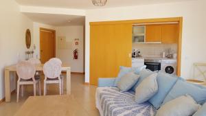 - un salon avec un canapé bleu et une table dans l'établissement T2 Cabanas Gardens piscina e praia, à Cabanas de Tavira