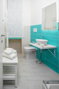La salle de bains est pourvue de toilettes et d'un lavabo. dans l'établissement Atena Rooms, à Cagliari
