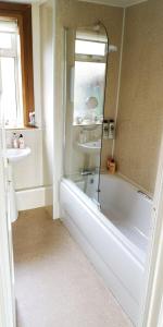 a bathroom with a bath tub and a sink at Ginger's in Stirling