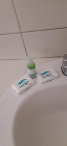 two toothbrushes and a bottle of medicine on a bathroom counter at Hotel Zacatecas Courts in Zacatecas