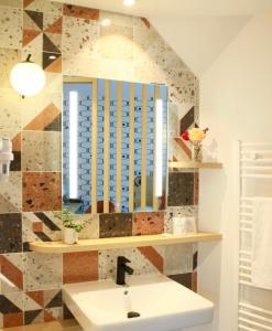 a bathroom with a sink and a mirror at Logis Hôtel Marguerite d'Anjou in Angers