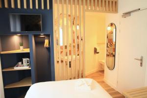 Cama ou camas em um quarto em Logis Hôtels- Hôtel Marguerite d'Anjou Angers château