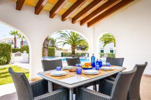 a patio with a table and chairs and a pool at Villa MARTINA in Cala en Forcat