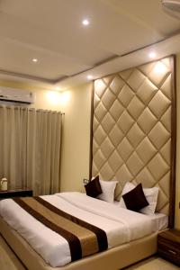 a bedroom with a large bed with a large headboard at Hotel Ganga Heights in Haridwār