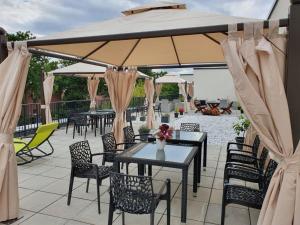 eine Terrasse mit Tischen und Stühlen unter einem großen Sonnenschirm in der Unterkunft Gästehaus Hansa Residence in Hamburg