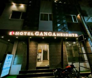 Una motocicleta estacionada frente a un edificio por la noche en Hotel Ganga Heights, en Haridwar