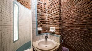 a bathroom with a sink and a brick wall at Casa de las Olas in Mazunte