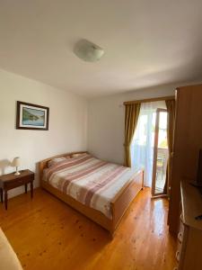 a bedroom with a bed and a table and a window at Apartments Popović in Žabljak