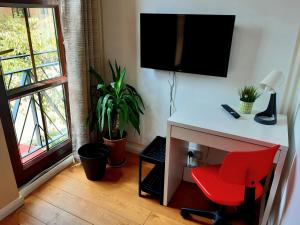 a desk with a red chair in a room with a window at Guest house with en-suite rooms and free parking in London