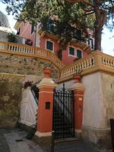 a pink house with a gate and a fence at La casa del girasole in Sestri Levante
